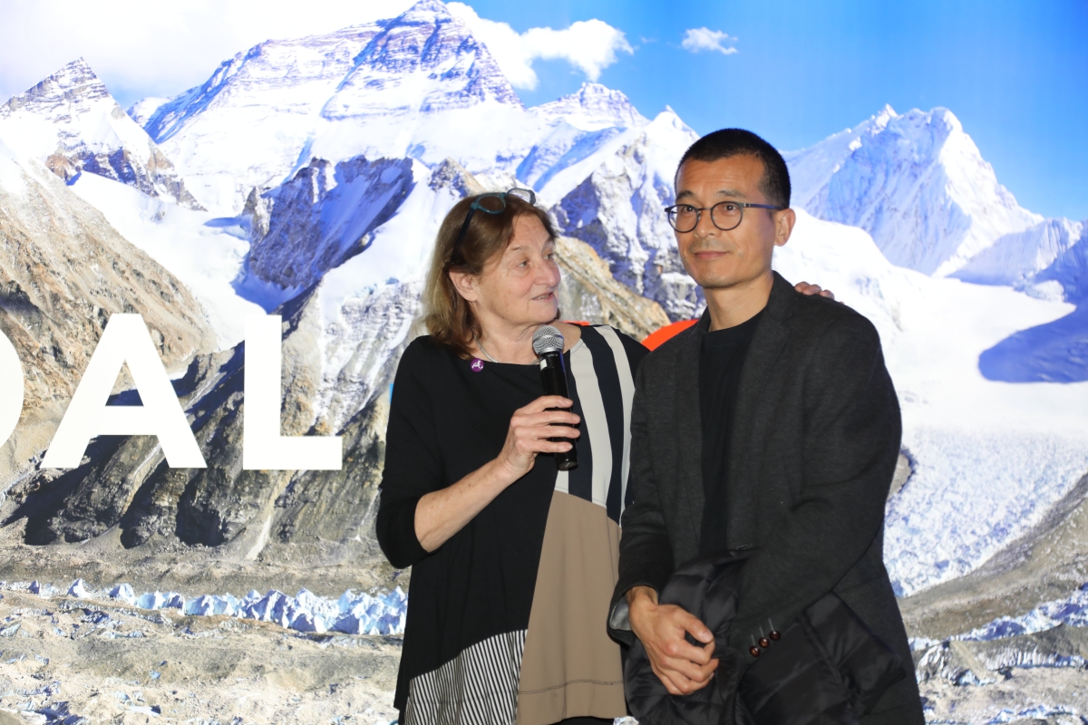 Curator Susan Meiselas stands next to Artist Song Chao at COAL + ICE opening