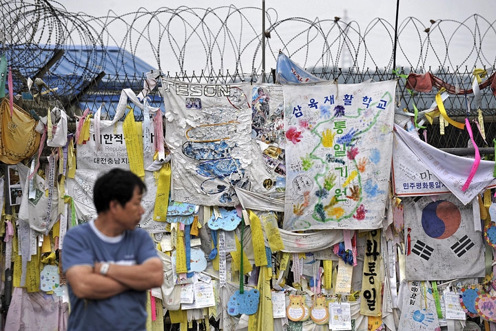 A man looks at reunification banners displayed on the fence of the Freedom Bridge, near the DMZ separating South and North Korea, in Paju on June 2, 2009.  (Philippe Lopez/AFP/Getty Images)