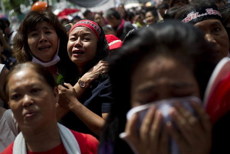 Thai "Red Shirt" anti-government protesters react as their leaders announce their surrender inside the protesters' camp in downtown Bangkok on May 19, 2010. Protest leaders told thousands of "Red Shirt" supporters to end their weeks-long rally after an army assault on their fortified encampment left at least five people dead. (Nicolas Asfouri/AFP/Getty Images)