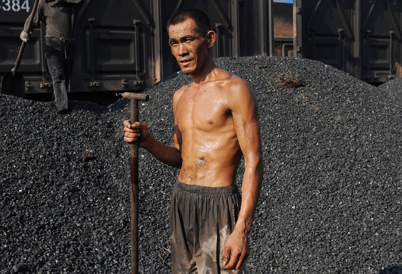A Chinese miner takes a break as he unloads coal from a train in Hefei, in eastern China's Anhui province on August 4, 2010. (STR/AFP/Getty Images)
