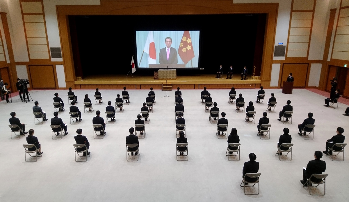New defense ministry employees listening to Defense Minister Taro Kono speak via video and spread out due to COVID-19.