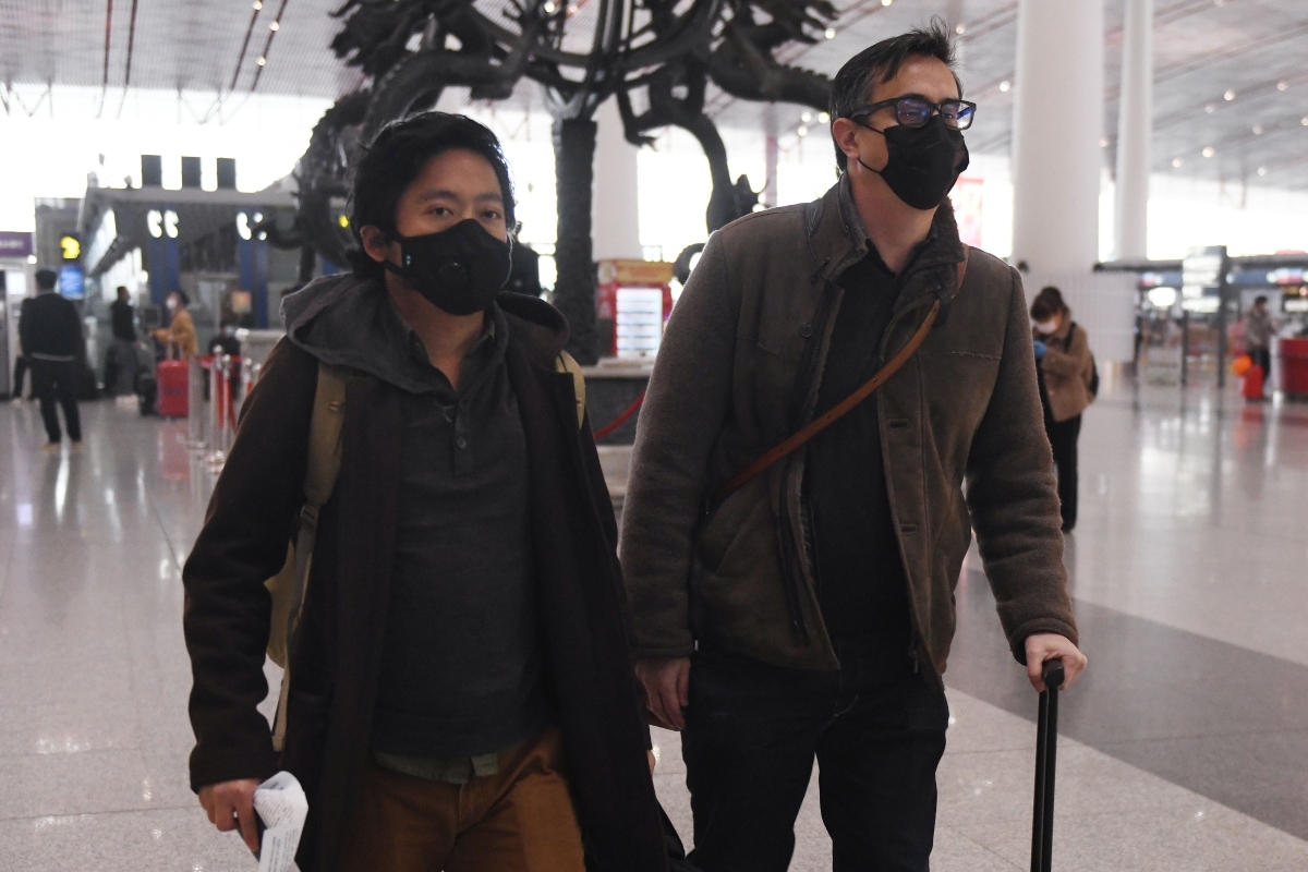 Wall Street Journal Reporters Philip Wen and Josh Chin walk through Beijing Airport following their ejection from China