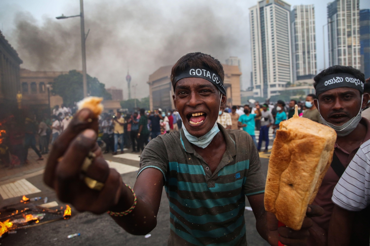 A supporter of Sri Lanka's main opposition displays a loaf of bread to highlight the rising food prices during a protest against the economic crisis that brought fuel shortages and inflation in Colombo, Sri Lanka, on March 15, 2022.