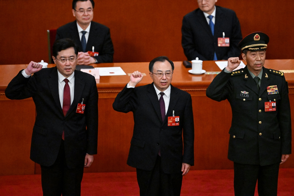 (L-R) Newly-elected Chinese state councilor Qin Gang, state councilor and secretary-general of the State Council Wu Zhenglong, state councilor Li Shangfu swear an oath after they were elected during the fifth plenary session of the National People's Congress (NPC) at the Great Hall of the People in Beijing on March 12, 2023.