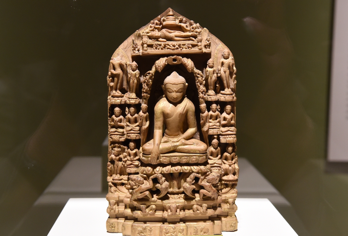 Carved sculpture of the sitting Buddha surrounded by smaller figures