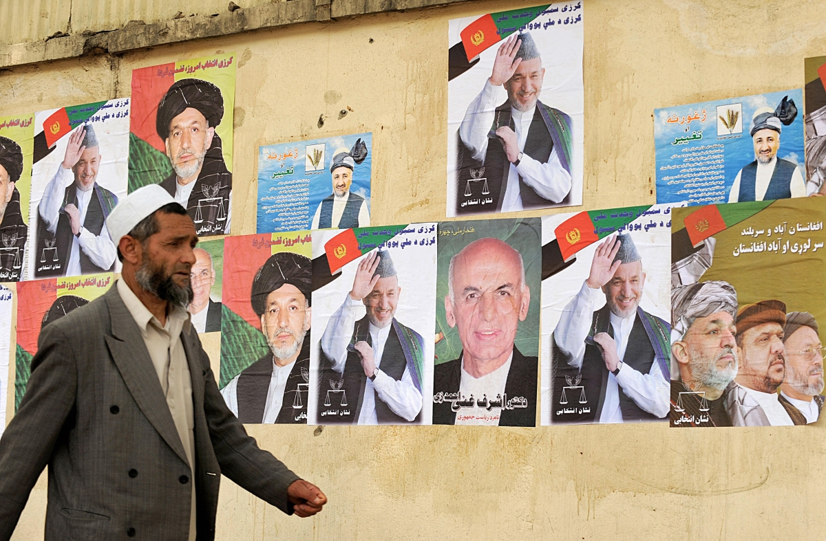 A man walks past posters of Aghan presidential candidates in Kabul on June 16, 2009. (Shah Marai/AFP/Getty Images)