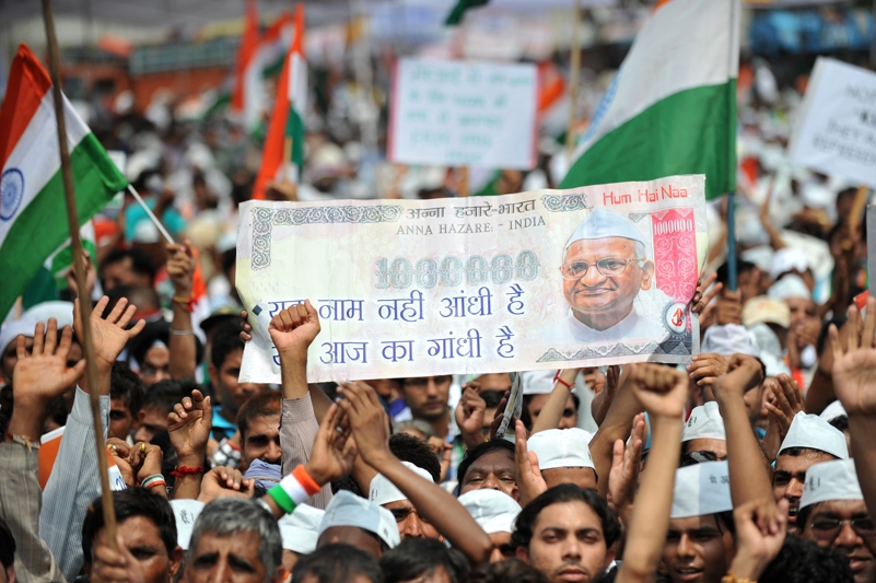 Supporters of the anti-corruption hunger strike by Indian activist Anna Hazare wave the national flag and hold up a fake Indian currency note depcting a portrait of Hazare during a rally in New Delhi on August 21, 2011. (Sajjad Hussain /AFP/Getty Images)  