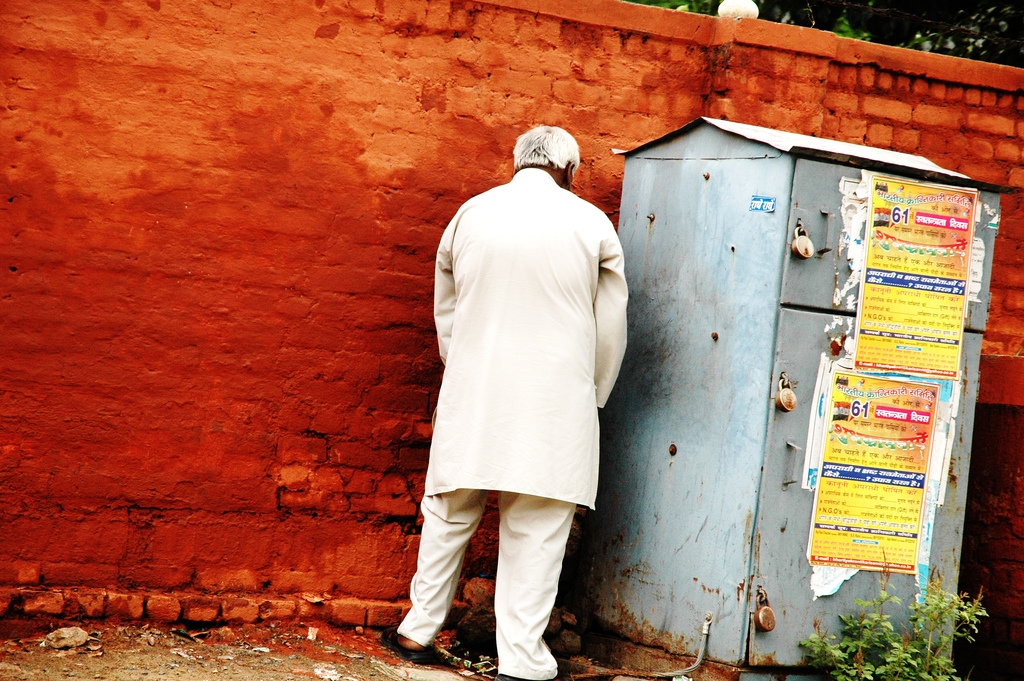 A man urinating on the roadside due to a lack of public toilets in India. (Pranav Singh/Flickr)