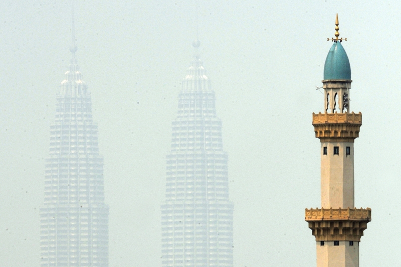 Malaysia's landmark Petronas Twin Towers are enveloped by haze behind the minerat of a mosque in Kuala Lumpur on June 12, 2009. (Saeed Khan/AFP/Getty Images)