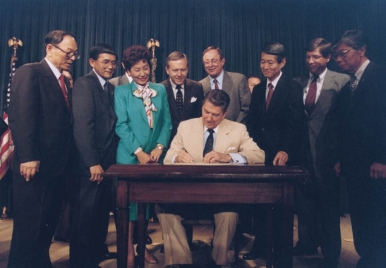 U.S. President Ronald Reagan signing the Japanese reparations bill in Washington, DC on August 10, 1988. (Ronald Reagan Library)
