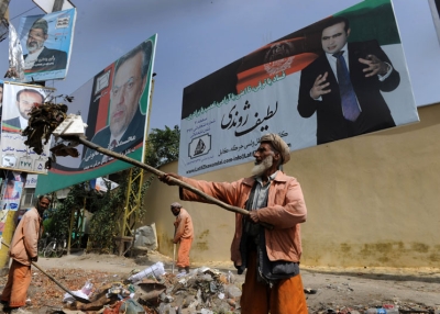  	 Afghan municipality workers clear garbage in front of parliamentary election campaign billboards of various candidates in Kabul on September 6, 2010. (Shah Marai/AFP/Getty Images) 