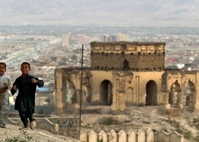 Young Afghan boys run on a hill-top past ruins in the old city of Kabul on September 16, 2010.