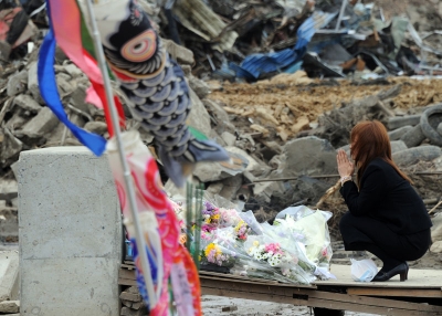 A mother prays for her missing child at the Okawa elementary school in the tsunami-devastated city of Ishinomaki, in Japan's Miyagi prefecture on May 11, 2011. (Toshifumi Kitamura/AFP/Getty Images)