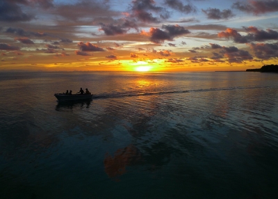 A speed boat zips away from the setting sun in Tabiteuea North, Kiribati on May 25, 2012. (Steve Bolton/Flickr)