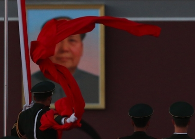 A paramilitary police officer collects the Chinese national flag during the flag-lowering ceremony at Tiananmen Square on November 13, 2012. (Feng Li/Getty Images)