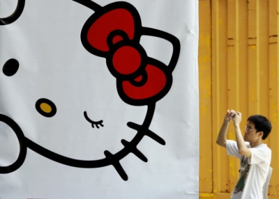 A man takes a picture next to a banner set up for an exhibition for popular animation character Hello Kitty in Hong Kong, 29 August 2005. (Phillipe Lopez/AFP/Getty Images)