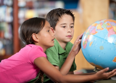 Two students look at a globe