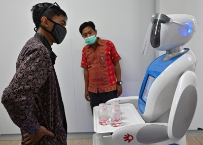 Indonesian technician with a robot during a simulation on assisting medical teams in handling COVID-19 coronavirus patients in Jakarta.