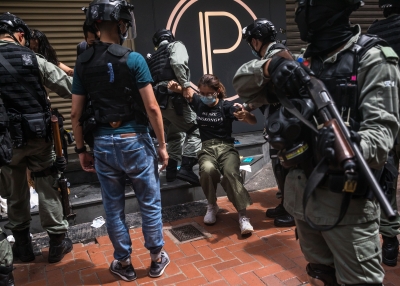 Riot police detaining a woman as they clear protesters taking part in a rally against a new national security law in Hong Kong.