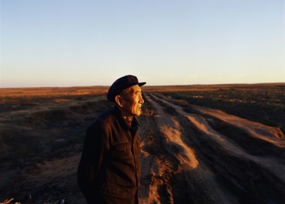 An elderly man looks towards the sunset