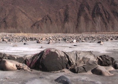 An unidentified woman lies dead on a riverbed bordering North Korea and China.