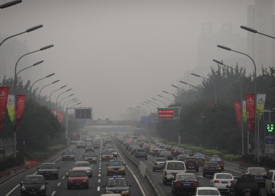 Cars drive through thick smog on a street in Beijing on Sept. 21, 2008, the first day of no traffic restrictions which limited motorists during the Olympic and Paralympic Games. (PETER PARKS/AFP/Getty Images)