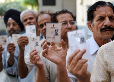 ndian voters hold up their voter ID cards as they stand in a queue to cast their vote at a polling station in Amritsar on May 13, 2009. (NarinderNanu/AFP/Getty Images)