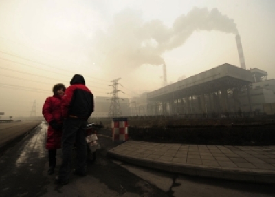 two people talk outside a coal-powered power plant on the outskirts of Linfen, in China's Shanxi province, on Dec. 8, 2009. (Peter Parks/AFP/Getty Images)