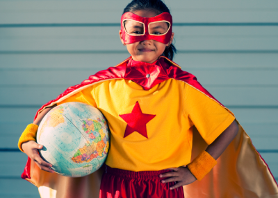 Girl dressed as superhero holding globe. (RichVintage/iStockPhotos)