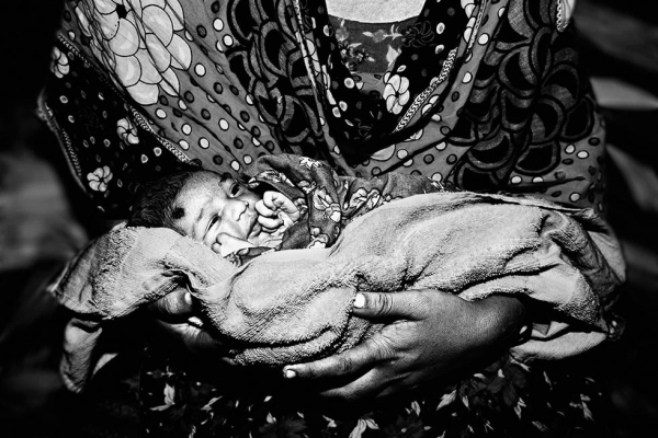 Ria, 12 hours old, is seen in her mother's lap in Dhaka, Bangladesh. (Gazi Nafis Ahmed)