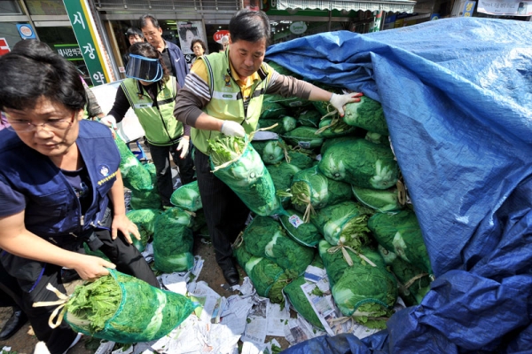 South Korean traders deliver cabbages, the basic ingredient to make kimchi, to clients at a market in Seoul on October 5, 2010. Bad weather this year has caused a serious cabbage shortage and a price spike, prompting South Korea to temporarily eliminate import duties on some vegetables. (Jung Yeon-Je/AFP/Getty Images) 