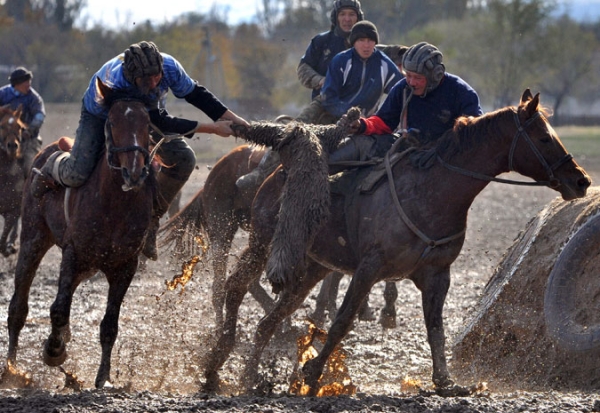 Mounted Kyrgyz men play the traditional Central Asian sport Buzkashi or Kok-boru or Oglak Tartis ('goat grabbing'), in Bishkek on November 4, 2010.