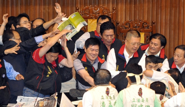 A book is thrown at a group of legislators from Taiwan&apos;s ruling Kuomintang party as they try to block their counterparts from occupying a podium at parliament in Taipei on July 8, 2010. (Patrick Lin/AFP/Getty Images)