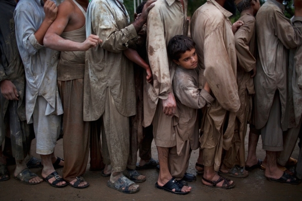 Survivors line up to receive water relief supplies from a local charity  in Pabi, near Nowshera, on August 3, 2010. (Daniel Berehulak/Getty Images)