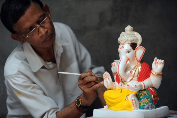 An artist gives finishing touches to a plaster cast idol of Lord Ganesh at a workshop in Pen village in Maharashtra on August 15, 2010. (Indranil Mukherjee/AFP/Getty Images)