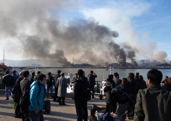 This photo taken by a South Korean tourist shows smoke rising from Yeonpyeong Island in the disputed waters of the Yellow Sea after North Korea fired dozens of artillery shells into the South Korean territory on Nov. 23, killing four people. The attack was North Korea&apos;s second lethal provocation in less than a year. (STR/AFP/Getty Images)