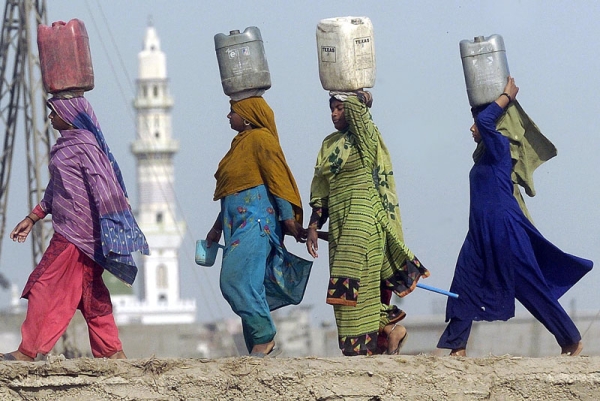 Pakistani women carry water in jerrycans on their heads in a slum area of Lahore. (Arif Ali/AFP/Getty Images)