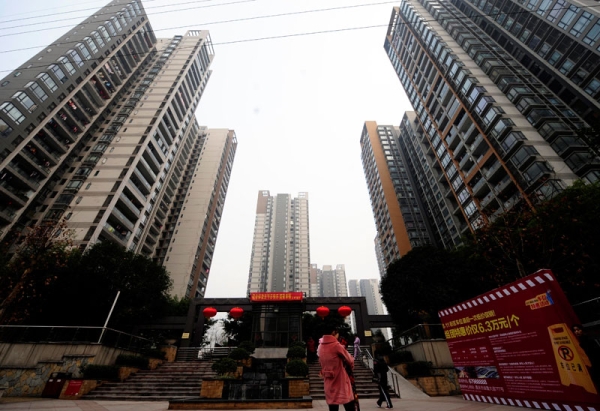 Pedestrians pass a courtyard between high-rise apartments in southwest China's Chongqing municipality on January 28, 2011. (STR/AFP/Getty Images)