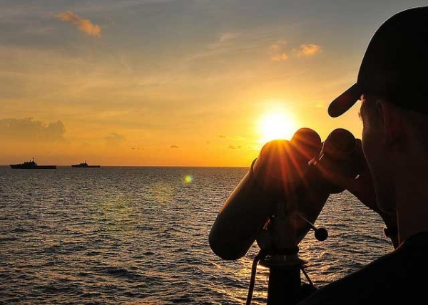 A U.S. Coast Guard seaman stands lookout watch in the South China Sea as two Republic of Singapore ships pass by U.S. Coast Guard Cutter Mellon during an exercise as part of Cooperation Afloat Readiness and Training (CARAT) on July 14, 2010. (CARAT/Flickr)