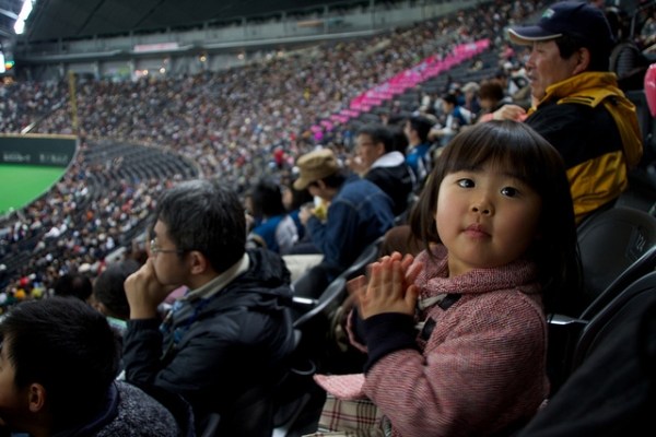A young baseball fan watches her first game in Sapporo, Japan on April 3, 2012. (MJ/TR (´･ω･)/Flickr)