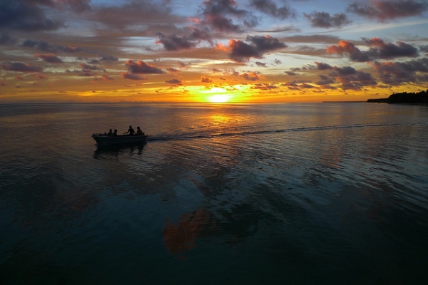 A speed boat zips away from the setting sun in Tabiteuea North, Kiribati on May 25, 2012. (Steve Bolton/Flickr)