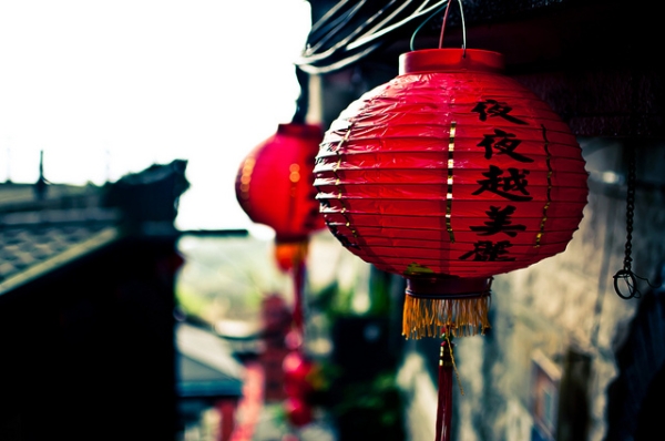 A red paper lantern hangs from teh side of a building in Taiwan on May 21, 2012. (acdovier/Flickr)