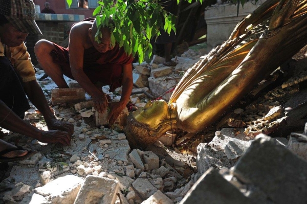 A Buddhist monk tries to salvage a statue of Buddha from a damaged building at a village in Sintgu township in central Myanmar on Nov. 12, 2012. (Soe Than Win/AFP/Getty Images)
