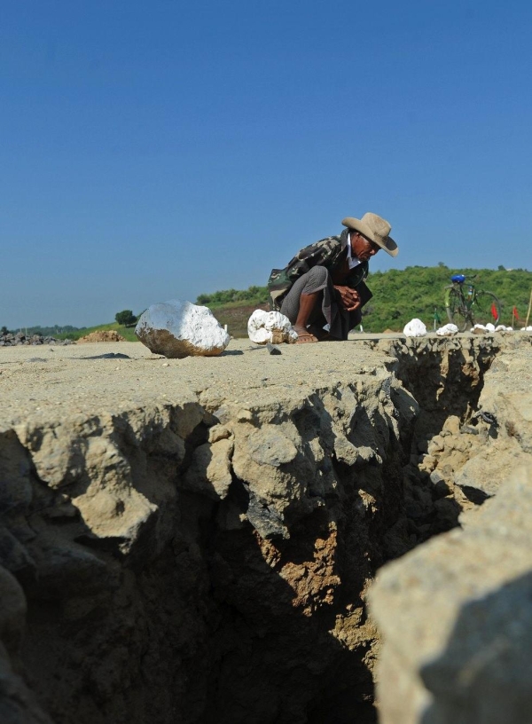 A villager looks at a crack in the road in Sintgu township in central Myanmar on Nov. 12, 2012. (Soe Than Win/AFP/Getty Images)