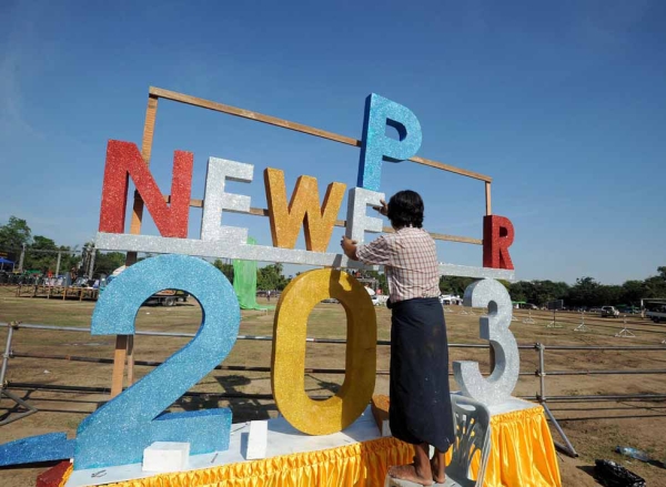 A worker puts up a sign ahead of Myanmar's first public New Year countdown celebration at the Myoma grounds in Yangon, Myanmar on December 31, 2012. (Soe Than WIN/AFP/Getty Images)