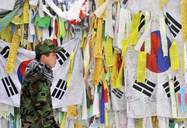 A South Korean soldier looks at "reunification ribbons" displayed on a military barbed wire fence at Imjingak Peace Park in Paju, near the Demilitarized Zone (DMZ) dividing the two Koreas, on January 1, 2013. (Jung Yeon-Je/AFP/Getty Images)