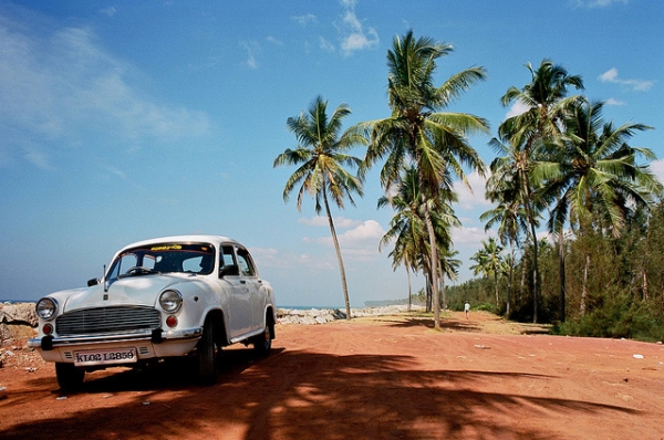 A white car sits stationary by the water in Kerala, India on January 24, 2013. (julien mrt/Flickr)