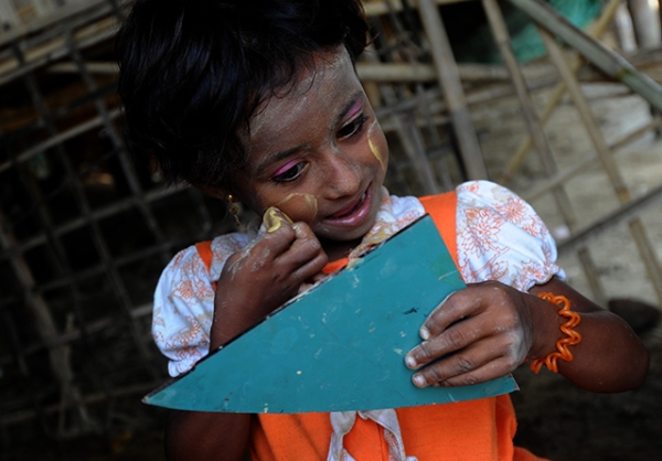 A child of the Rohingya minority group applies a traditional cosmetic paste at an IDP camp in Sittwe, Myanmar on May 18, 2013. (Soe Than Win/AFP/Getty Images)
