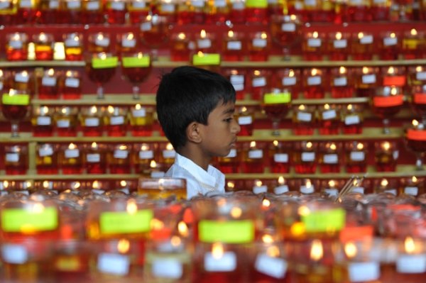 A young Buddhist devotee walks past rows of candles for Vesak Day celebrations at a Buddhist temple in Kuala Lumpur, Malaysia on May 24, 2013. (Mohd Rafsan/AFP/Getty Images)