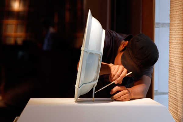 Art handler Hiroaki Sato adds some finishing touches to a display stand. (Tahiat Mahboob/Asia Society)